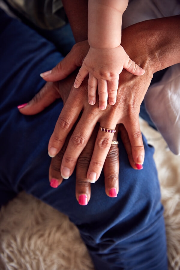 Three generations of a family with their hands stacked together.